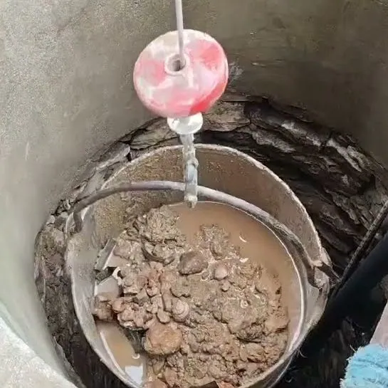Кофа с изгребана утайка, камъни и пясък, изтеглена от дъното на кладенец